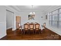 Formal dining room featuring wainscoting, elegant chandelier, and large windows, perfect for entertaining at 409 Wheatberry Hill Dr, Matthews, NC 28104