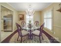 Charming dining room featuring hardwood floors, shuttered windows, and elegant chandelier lighting at 5411 Valley Forge Rd, Charlotte, NC 28210