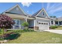 Beautiful home exterior with well-maintained landscaping, a covered porch, and a two-car garage at 6136 Sandy Point Ln, Belmont, NC 28012