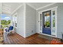 Inviting front porch with a comfortable seating area and a stylish blue front door with sidelights at 6136 Sandy Point Ln, Belmont, NC 28012
