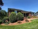 Inviting brick ranch-style home with mature trees and a well-kept lawn at 6339 River Front Dr, Harrisburg, NC 28075
