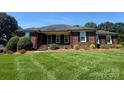 Lovely one-story brick home features a lush lawn and established landscaping at 6339 River Front Dr, Harrisburg, NC 28075