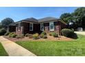 Single-story brick house boasts a beautifully maintained front yard and landscaping at 6339 River Front Dr, Harrisburg, NC 28075