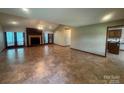 Spacious living room with fireplace, tile flooring, and sunroom access at 6339 River Front Dr, Harrisburg, NC 28075