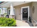 Close-up of the front door with a welcoming wreath, sidelight window, and stone-accented porch column at 7318 Rupell Dr, Charlotte, NC 28273