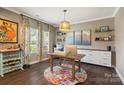 Bright home office featuring a wooden desk, custom curtains, and a built-in storage unit at 7318 Rupell Dr, Charlotte, NC 28273