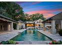 Luxury pool featuring a stone surround, cabanas, and a stunning view of the elegant home and its architecture at 8300 Fairview Rd, Charlotte, NC 28226