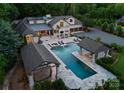 Aerial view of an exquisite backyard with a large pool, spa, cabanas, outdoor bar, and entertainment area at 8300 Fairview Rd, Charlotte, NC 28226