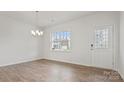 Bright living room with hardwood floors, large window, and decorative front door with windowed sidelight at 9528 Maltese Dr, Gastonia, NC 28056