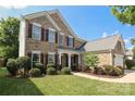 Inviting two-story home with brick facade, manicured lawn, and a welcoming front entrance at 10217 Falling Leaf Dr, Concord, NC 28027