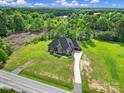 Spacious home with a long driveway, surrounded by lush greenery and mature trees at 1166 Rocky River Rd, Lancaster, SC 29720