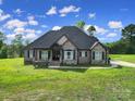 Beautiful exterior view of a home with stone accents and lush green lawn at 1166 Rocky River Rd, Lancaster, SC 29720