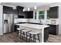 Modern kitchen with black cabinets, stainless steel appliances, and a central island with bar seating at 12305 Gambrell Dr, Charlotte, NC 28278