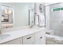Bright bathroom with double sinks, quartz countertops, white cabinets, and tiled shower with glass door at 12309 Gambrell Dr, Charlotte, NC 28278