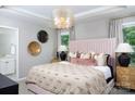 Luxurious bedroom featuring a plush bed, stylish lighting, tray ceilings, and ensuite bathroom access at 12309 Gambrell Dr, Charlotte, NC 28278