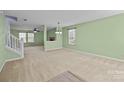 Open living room with neutral carpet, bright green walls, and plenty of natural light at 12724 Frank Wiley Ln, Charlotte, NC 28278