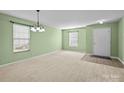 Bright living room with neutral carpet, a front door, and a large window at 12724 Frank Wiley Ln, Charlotte, NC 28278