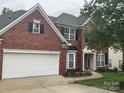 A two-story brick home with an attached two-car garage and meticulously maintained lawn and landscaping at 13123 Ashley Meadow Dr, Charlotte, NC 28213