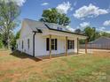 Side angle of white farmhouse featuring a gray roof and covered front porch at 1454 King Rd, York, SC 29745