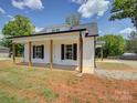 Inviting home showcasing a covered front porch with wood columns and dark window shutters at 1454 King Rd, York, SC 29745