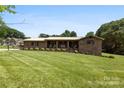 Charming brick home with covered porch and meticulously striped lawn in a picturesque setting at 1512 Mount Ulla Hwy, Mooresville, NC 28115