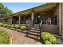 Inviting brick home entrance featuring a covered porch, black railings, and manicured landscaping at 1512 Mount Ulla Hwy, Mooresville, NC 28115