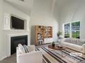 Bright living room featuring a fireplace, large windows, and modern furnishings at 177 Jacobs Woods Cir, Troutman, NC 28166
