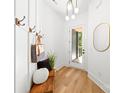 Bright entryway with stylish accents, wooden bench, coat hooks, and modern lighting fixture at 2006 St John St, Charlotte, NC 28216