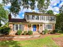 Charming two-story home with a brick and siding exterior, featuring a bright blue front door and landscaped yard at 2315 Lawton Bluff Rd, Charlotte, NC 28226