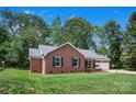 Charming brick ranch home with an attached garage, side porch with swing, and beautiful green lawn at 2502 Gold Rush Dr, Lincolnton, NC 28092
