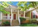 Inviting covered front porch with white railings and brick steps with nice landscaping at 2923 Meadow Creek Ln, Monroe, NC 28110