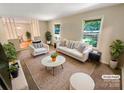 Bright living room features neutral walls, large windows offering nice views, and modern furniture arrangement at 3203 Oakdale Dr, Monroe, NC 28110