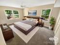 Well-lit main bedroom featuring a large bed, soft carpet, and scenic views from the oversized windows at 3203 Oakdale Dr, Monroe, NC 28110