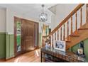 Warm foyer showcasing hardwood floors, decorative wainscoting, and an elegant wooden staircase at 341 N Mulberry St, Statesville, NC 28677