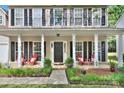 Inviting front porch with comfortable seating, black shutters, and an elegant front door at 3632 Cole Mill Rd, Charlotte, NC 28270