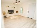 Cozy living room with brick fireplace, ceiling fan, and light blue door at 383 Camden Nw Ct, Concord, NC 28027