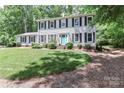 Charming two-story home with a manicured lawn and a lovely blue front door and mature trees at 417 Florence Cir, Statesville, NC 28625