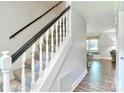 Elegant staircase with carpeted steps, dark handrail, and white spindles, providing a classic touch to the home's interior at 417 Florence Cir, Statesville, NC 28625