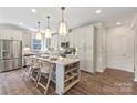 Modern kitchen featuring white cabinets, a large island with seating, and stainless steel appliances at 527 Sunharvest Ln, Indian Trail, NC 28079