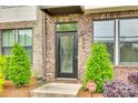 Front entrance featuring a black door, brick facade, and manicured landscaping at 556 Billingsley Rd, Charlotte, NC 28211