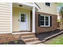 Inviting front entrance with a white door, brick steps, and manicured landscaping at 6713 William Harry Ct, Charlotte, NC 28211