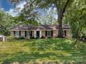 A beautiful, brick home with an expansive lawn, mature trees, and a classic architectural style at 6922 Woodstock Dr, Charlotte, NC 28210