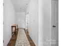 Bright hallway with a patterned runner and white walls, leading to the main living areas of the home at 699 Kitfox Nw Dr, Concord, NC 28027