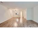 Spacious living room featuring modern wood-look flooring and neutral paint at 8221 Pineville Matthews Rd # G, Charlotte, NC 28226