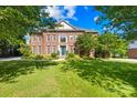 A beautiful brick home with mature trees and a well-manicured lawn at 9311 St Barts Ln, Huntersville, NC 28078