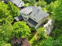 A beautiful backyard view of the home featuring a patio, deck and pristine landscaping at 9311 St Barts Ln, Huntersville, NC 28078