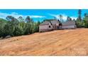 Side view of a new home with white siding, dark trim and a sloped lot at 124 Starboard Ln, Statesville, NC 28677