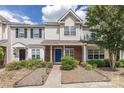 Charming townhome featuring a blue front door, brick facade and manicured landscaping at 12749 Mosby Ln, Charlotte, NC 28273