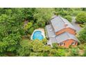 Aerial view of a brick home with a pool, screened porch, and lush landscaping at 1285 10Th Street Nw Blvd, Hickory, NC 28601