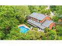 A brick home with a pool and patio area surrounded by trees at 1285 10Th Street Nw Blvd, Hickory, NC 28601